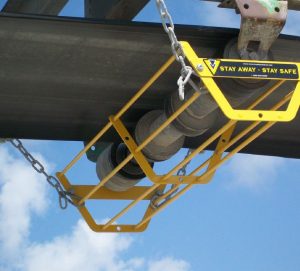 A return idler basket securing a belt idler against falling on workers below.