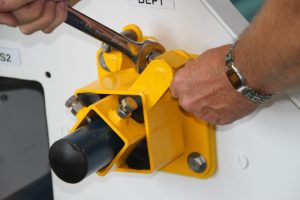 Man demonstrating how belt scraper blade mounts work